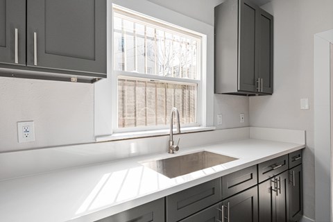 A kitchen with a white countertop and a window at Hillstone Flats Apartments, Los Angeles, California