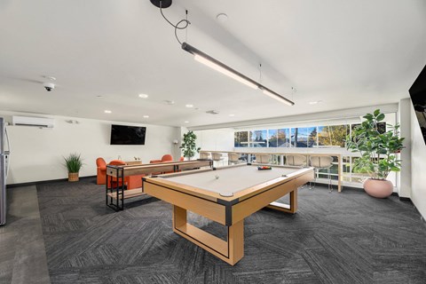 A room with a pool table and a television.
