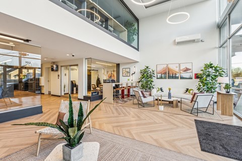 A modern office space with wooden floors and a variety of seating options.