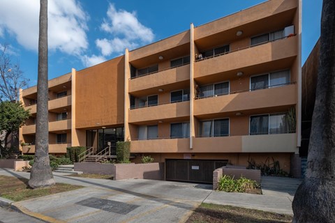 A large apartment building with a parking lot in front at Menlo Terrace Apartments, California 90006