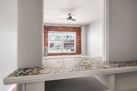 A room with a brick wall and a ceiling fan at Normandie Summit Apartments, Los Angeles