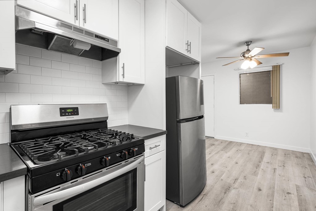 A modern kitchen with a stainless steel gas stove and a refrigerator. A modern kitchen with a stainless steel gas stove and a refrigerator.at Palms at Menlo, Los Angeles, CA 90006