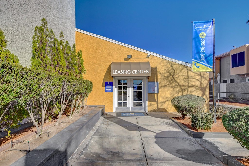 The image shows the entrance to a leasing center with a blue banner hanging above the door.