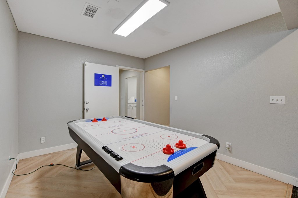 A pool table in a room with a blue sign on the door.