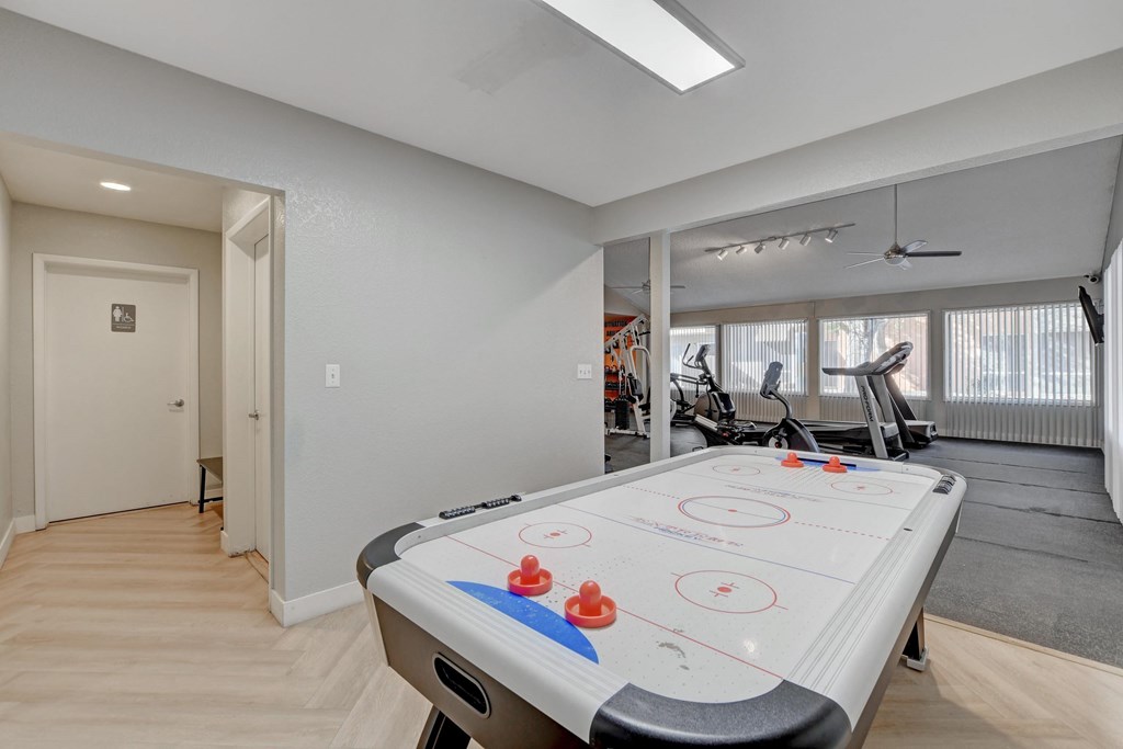 A room with a foosball table in the middle.