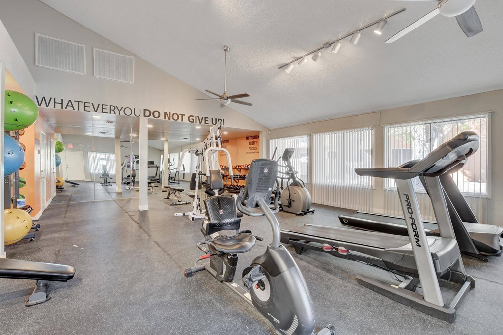 A gym with a variety of equipment including treadmills and exercise balls.