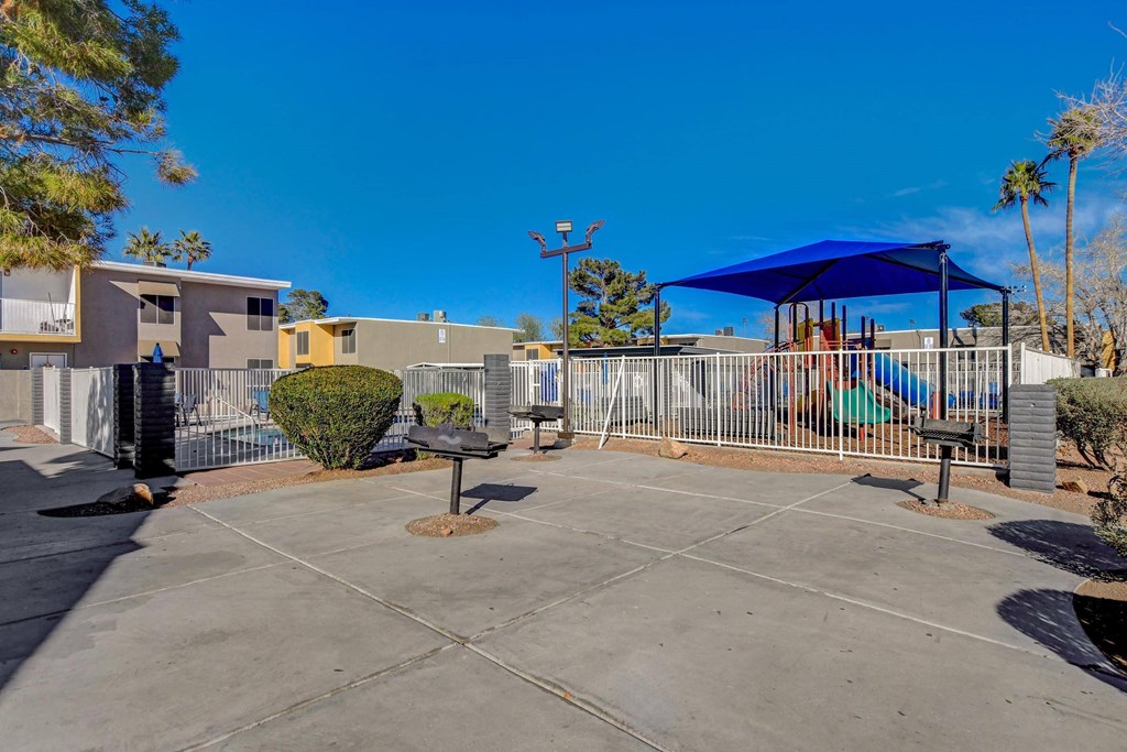 A sunny day at the community pool with a blue shade structure.
