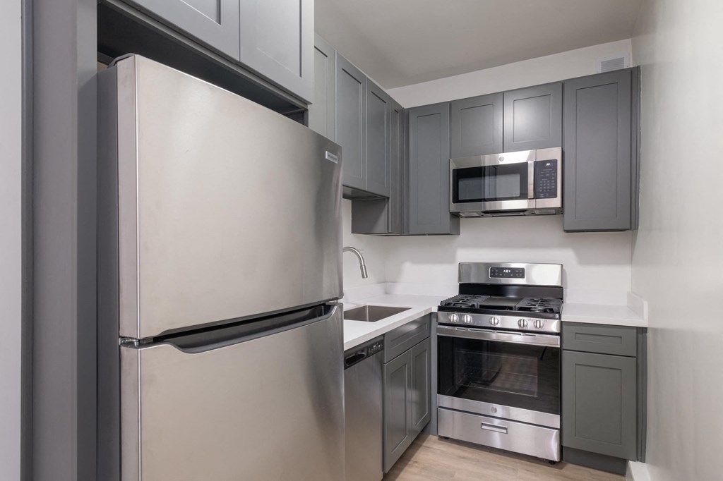 A modern kitchen with a stainless steel refrigerator and oven.