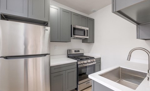 A kitchen with a stainless steel refrigerator, microwave, and oven at Westmore Manor Apartments, Los Angeles, CA, 90020