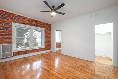 A room with a ceiling fan and wooden floors.