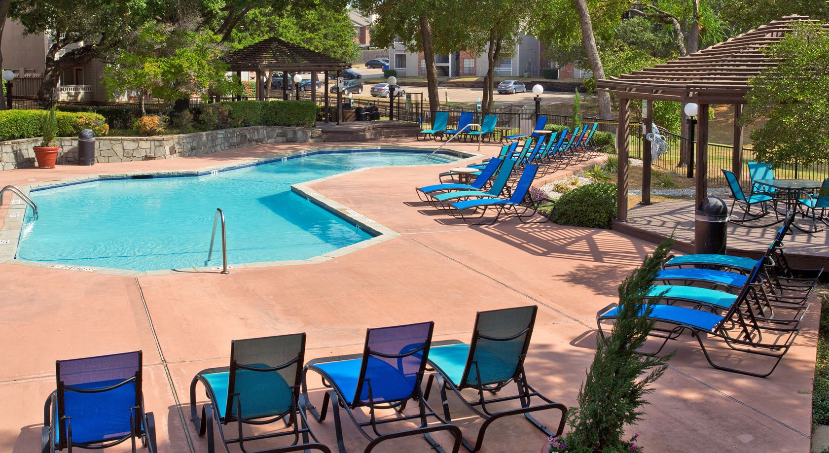 Swimming Pool Area With Shaded Chairs at Foxborough Apartments, Irving