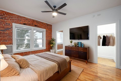 A bedroom with a brick wall and a large bed at Westmore Manor Apartments, California, 90020