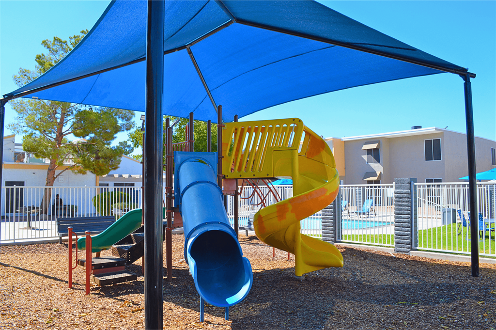 a playground with a blue umbrella and a slide at Summer Meadows, Nevada