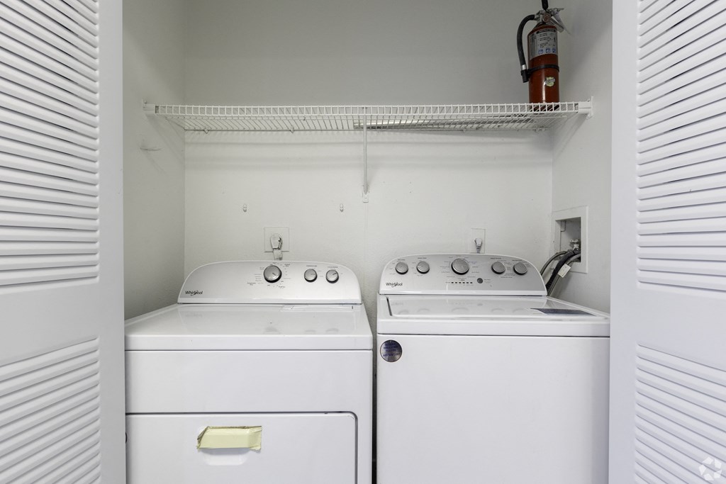 an empty laundry room with two washes and a dryer