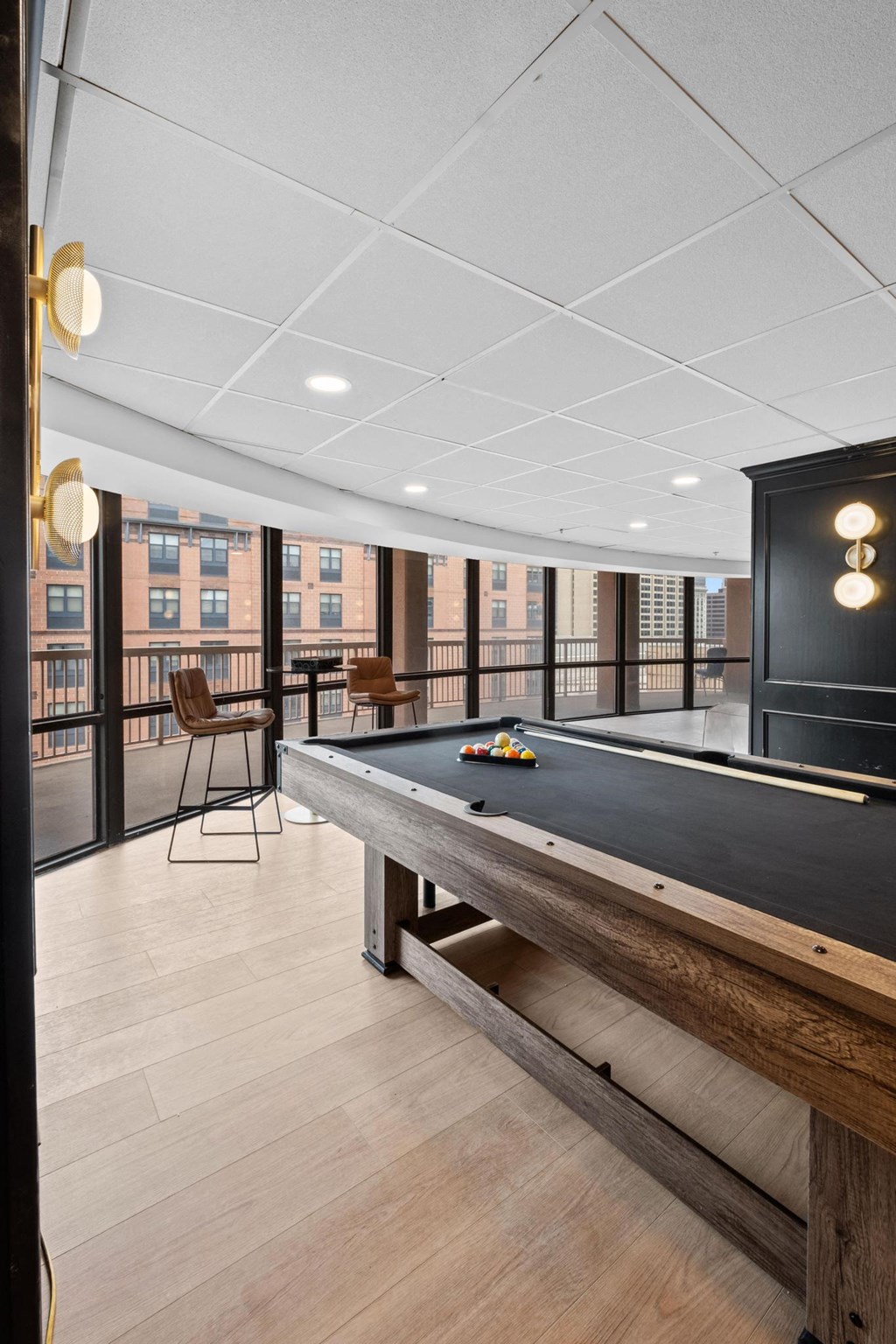a pool table in a game room with a view of the city at Vision on Lombard, Baltimore, MD
