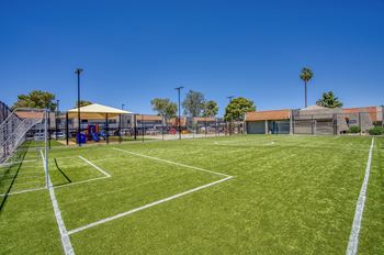 A tennis court with a white line and a yellow canopy tent.