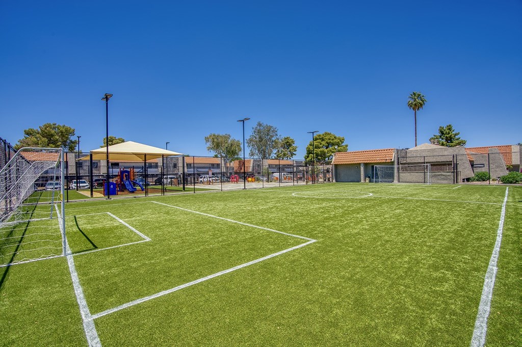 A tennis court with a white line and a yellow canopy tent.