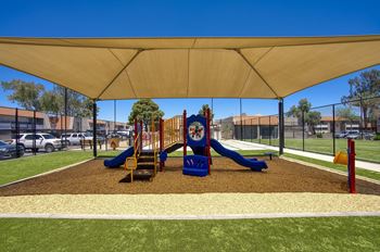 A playground with a blue slide and yellow and red play equipment.