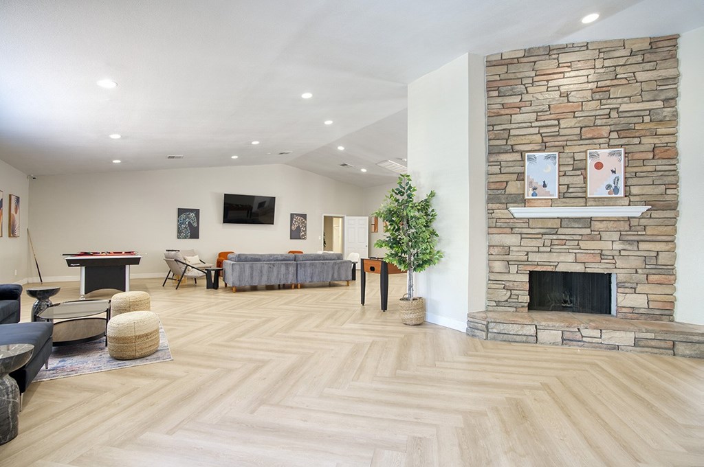 A living room with a stone fireplace and a television.