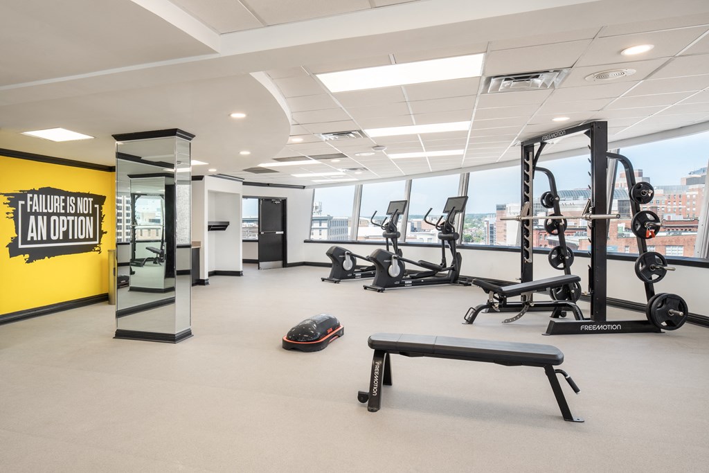 a workout room with weights and other exercise equipment in a building with a large window at Vision on Lombard, Baltimore, MD 21201