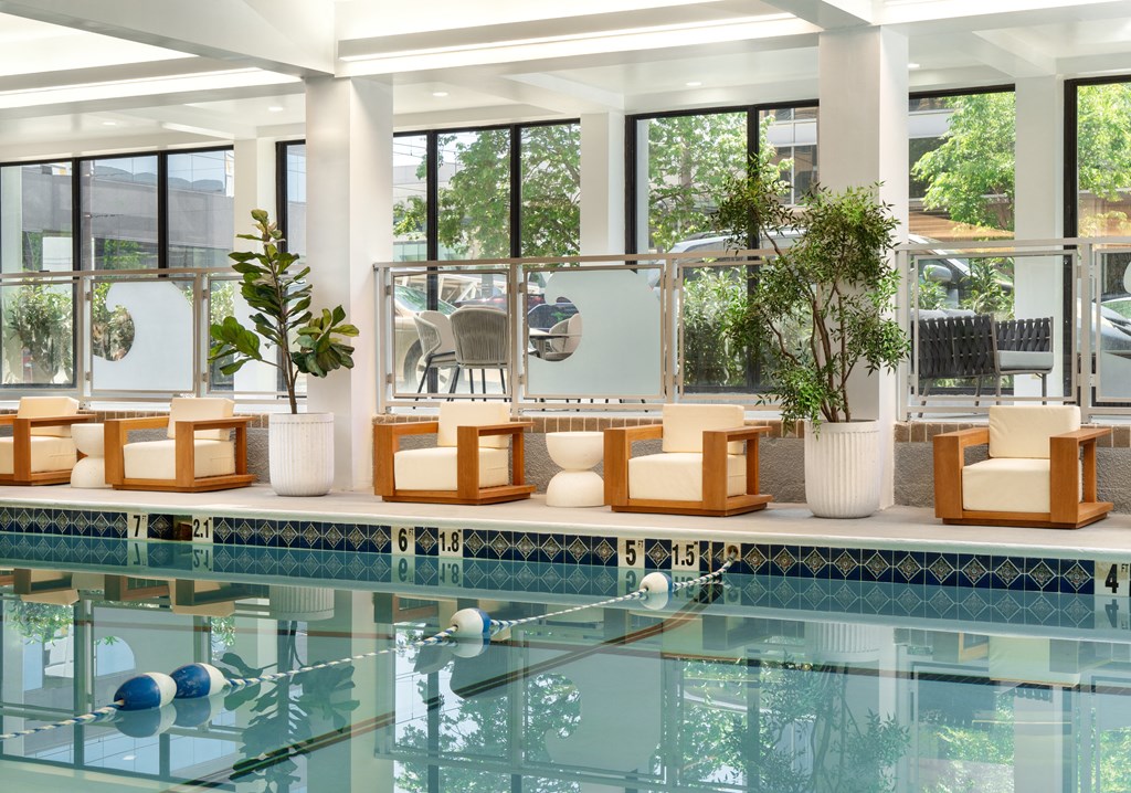 a swimming pool in a hotel with lounge chairs next to it at Vision on Lombard, Baltimore, 21201