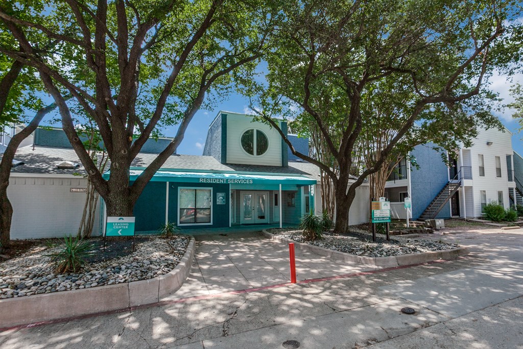 a green building with trees in front of it