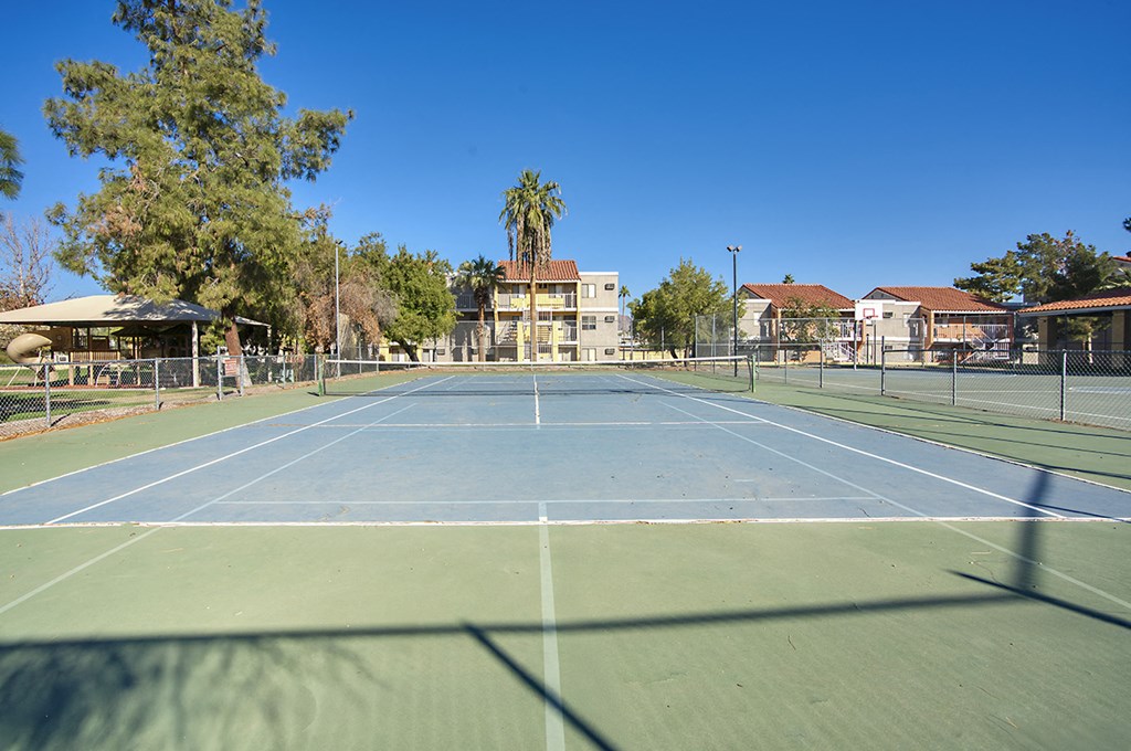 A tennis court with a blue sky in the background.