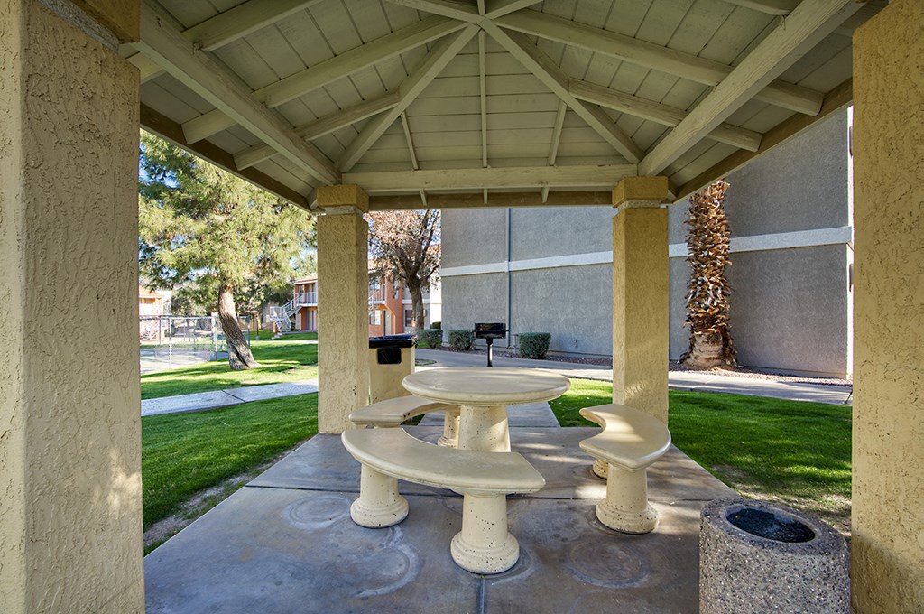 A white pedestal sink is in the middle of a concrete patio.