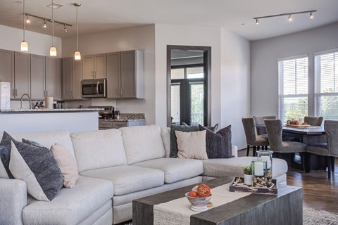 A modern living room with a grey sofa and a wooden coffee table.
