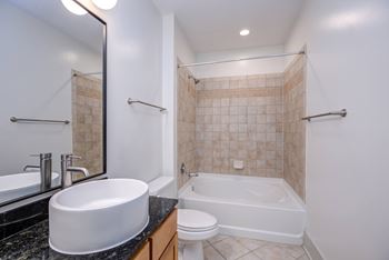 A white sink is on a black countertop in a bathroom.