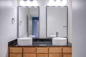 A bathroom with two sinks and two mirrors.