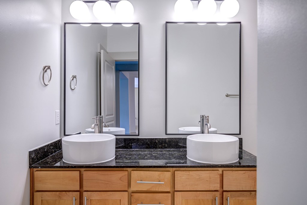 A bathroom with two sinks and two mirrors.