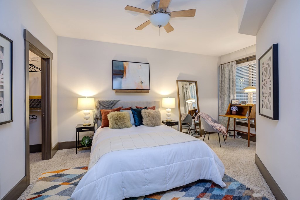 A bedroom with a large bed and a ceiling fan.