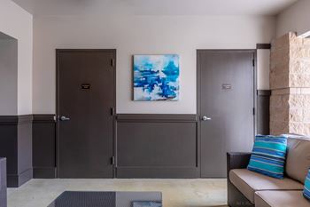 A room with a brown couch and a painting on the wall.