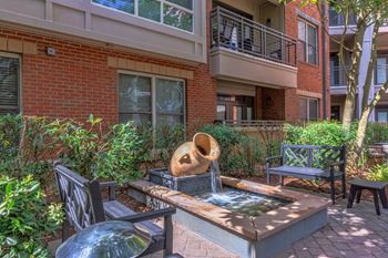 A patio with a fountain and chairs.
