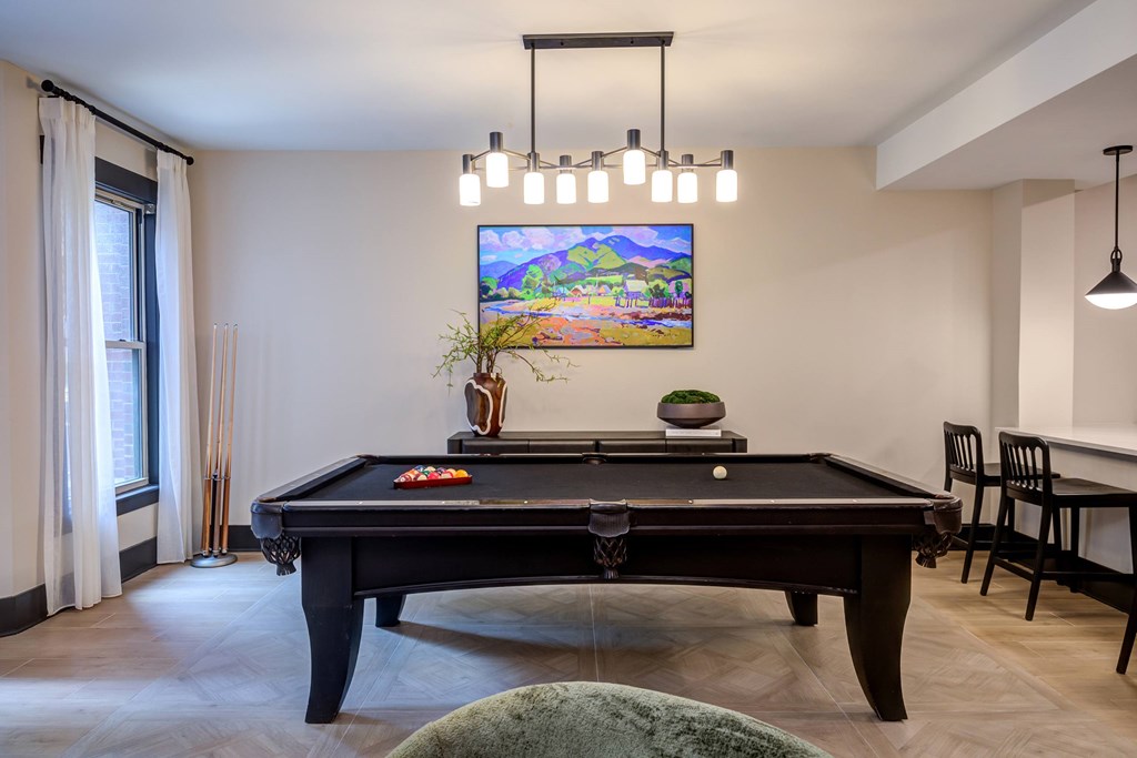 A  room with a pool table and a TV on the wall.