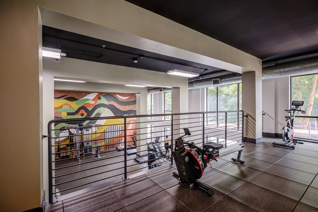A room with a mural on the wall and exercise equipment.