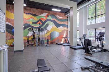 A gym with a colorful mural on the wall.