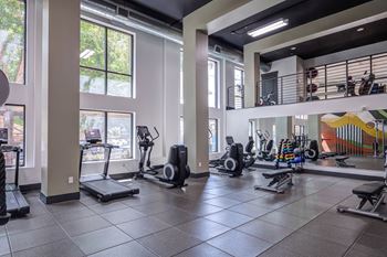A gym with treadmills, exercise bikes, and other equipment.