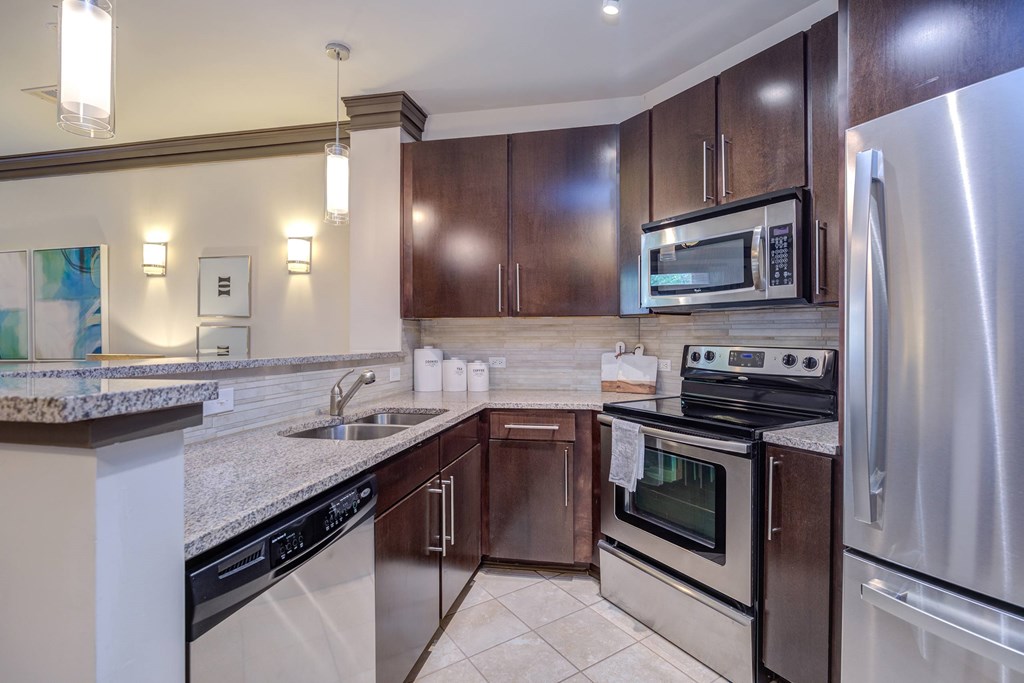 A kitchen with a stove top oven and a refrigerator.