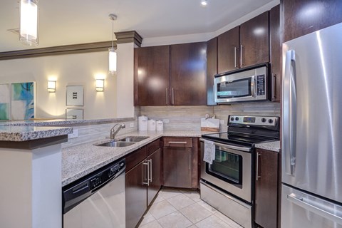 A kitchen with a stove top oven and a refrigerator.