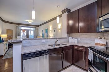 A kitchen with dark brown cabinets and a white counter.