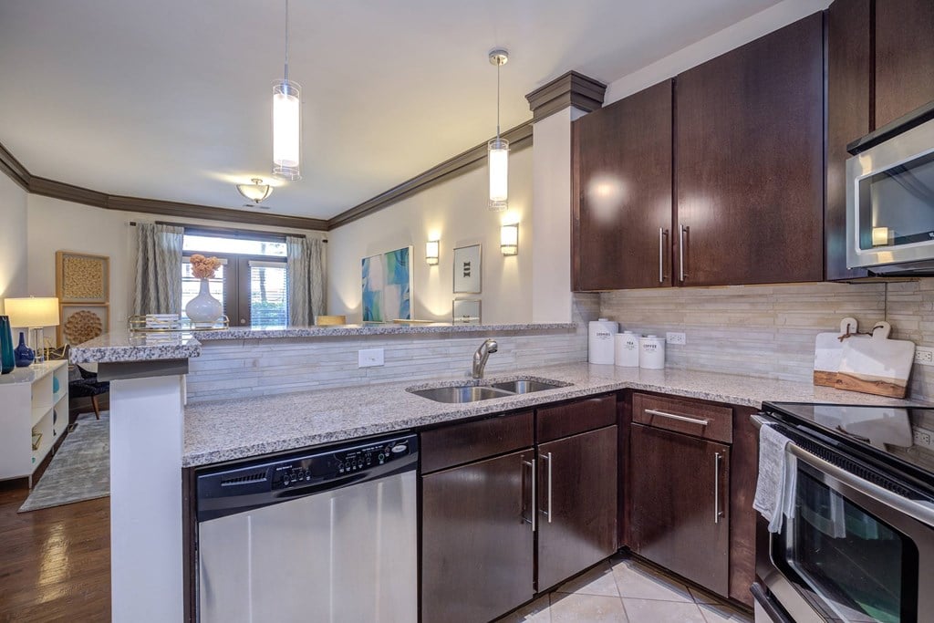 A kitchen with dark brown cabinets and a white counter.