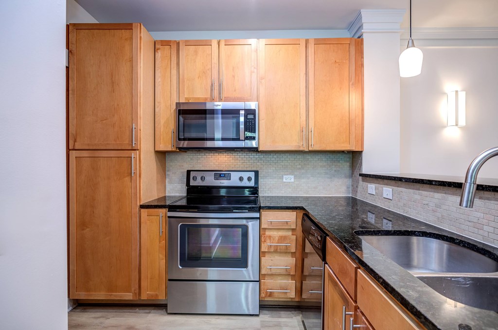 A kitchen with wooden cabinets and a stainless steel sink.