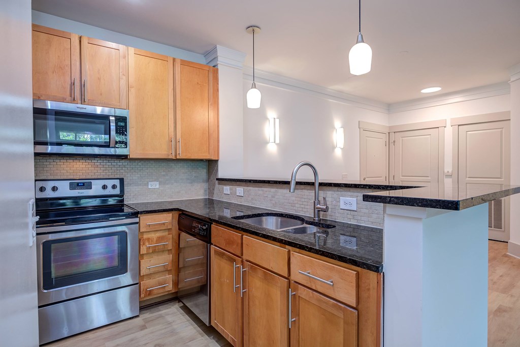 A kitchen with wooden cabinets and a black countertop.