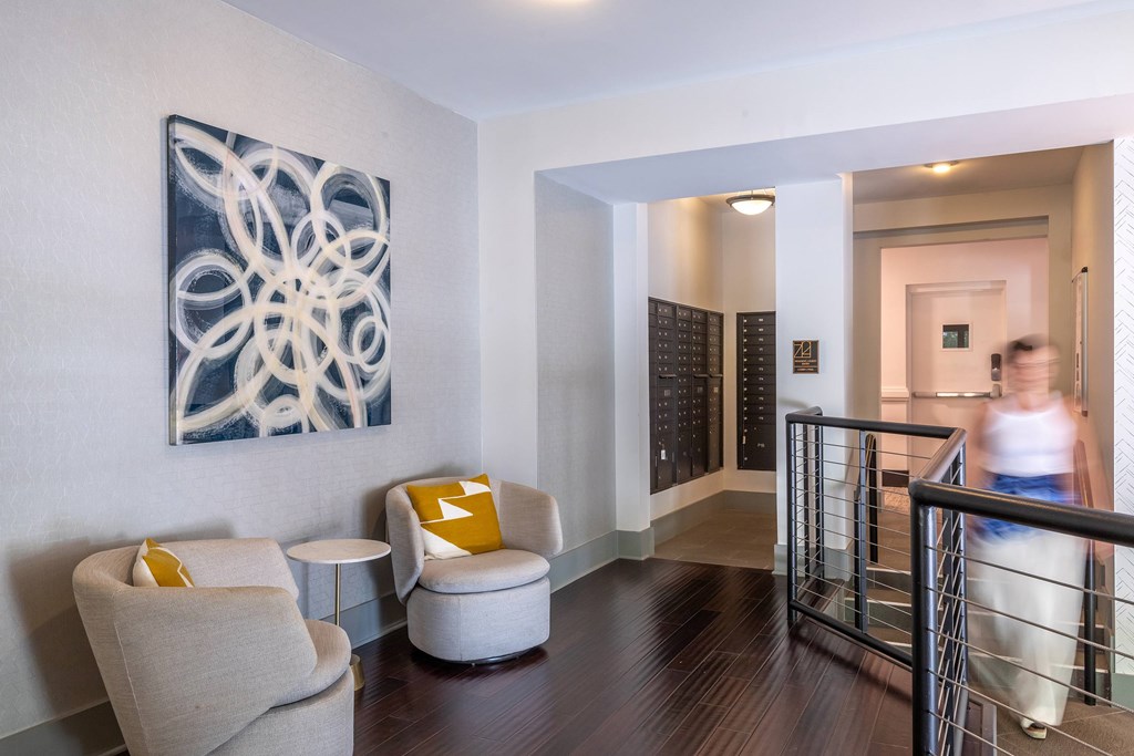 A modern room with a large abstract painting on the wall and a person walking in the background.