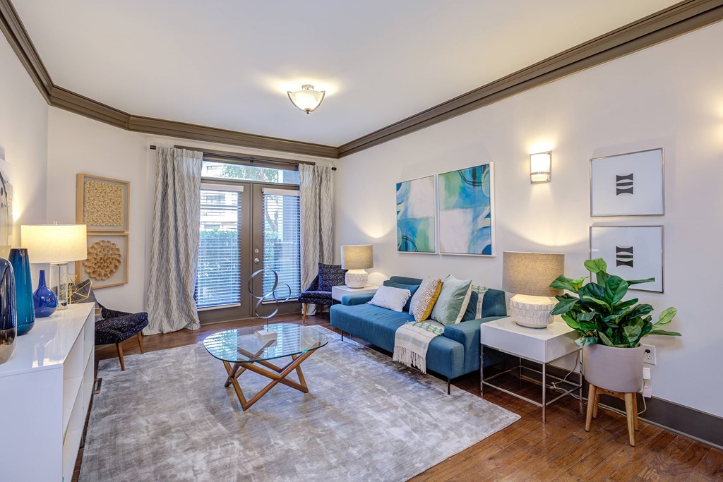 A living room with a blue couch and a white coffee table.