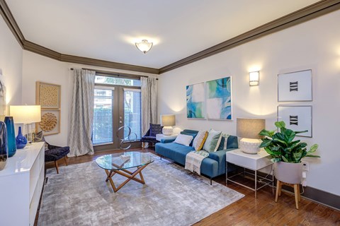 A living room with a blue couch and a white coffee table.