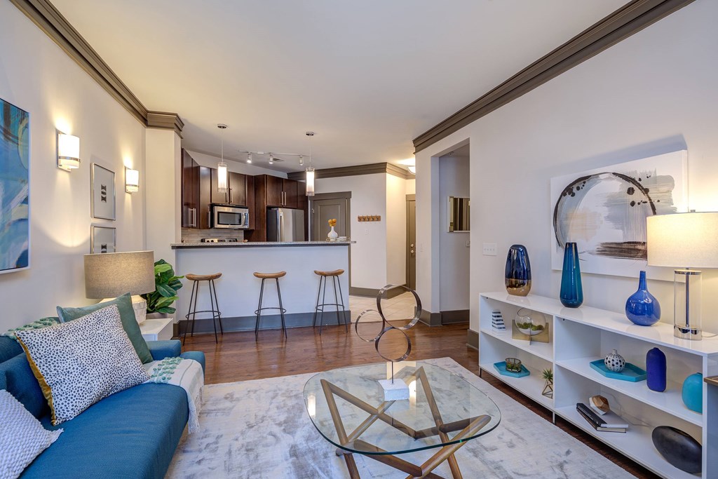 A modern living room with a blue couch and a glass coffee table.
