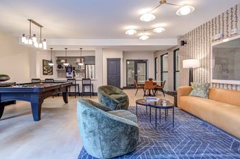 A living room with a pool table and a couch.